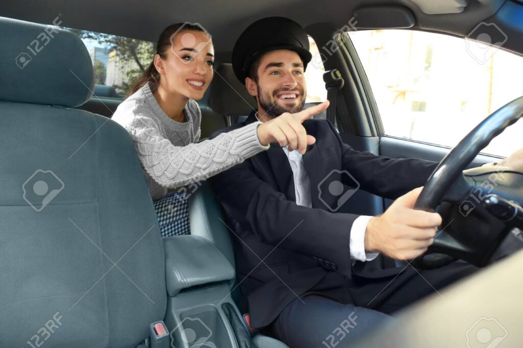 Young female passenger showing taxi driver the way
